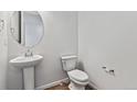 Clean powder room featuring a modern pedestal sink and toilet at 9092 Telluride Ct, Commerce City, CO 80022