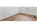 Bright bedroom featuring sleek wood floors and ample natural light from the window at 9092 Telluride Ct, Commerce City, CO 80022