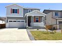 Charming two-story home with a covered porch, gray siding, and a well-maintained front yard at 9092 Telluride Ct, Commerce City, CO 80022