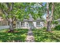 Charming single-story home featuring a well-kept lawn, grey paint and mature landscaping at 1177 Wabash St, Denver, CO 80220