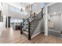 Bright and airy living room with a high ceiling, a decorative fireplace, and elegant staircase at 3444 Recess Pt, Castle Rock, CO 80108