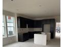 Unfinished kitchen featuring modern dark cabinets, stainless appliance space, white walls, and natural light at 6562 Arbor Blvd # 5, Thornton, CO 80602