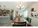 Inviting dining area with a wooden table, stylish chandelier, and convenient access to the kitchen and backyard at 1450 Syracuse St, Denver, CO 80220