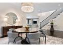 Elegant dining room featuring a chandelier, modern furniture, and a staircase in the background at 450 Steele St, Denver, CO 80206