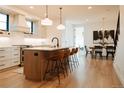 Modern kitchen featuring hardwood floors, an island with barstools and pendant lights, and stainless steel appliances at 527 Fox St, Denver, CO 80204