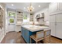 Bright kitchen with custom island, white cabinetry, and stainless steel appliances at 4535 E Montview Blvd, Denver, CO 80207