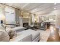 Elegant living room featuring a fireplace, hardwood floors, and coffered ceilings at 4535 E Montview Blvd, Denver, CO 80207