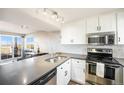 Modern kitchen featuring stainless steel appliances, white cabinets, and a breakfast bar overlooking the dining area at 2179 Sunridge Cir, Broomfield, CO 80020