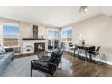 Cozy living room with a fireplace and large windows offering panoramic views and a dining area at 2179 Sunridge Cir, Broomfield, CO 80020