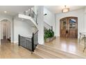 Elegant foyer with hardwood floors, grand staircase, and a large wooden door at 7952 Dante Dr, Littleton, CO 80125