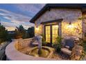 Charming stone courtyard featuring a fountain, seating area, and lovely landscaping at 7952 Dante Dr, Littleton, CO 80125
