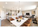 Open concept kitchen and dining area with modern island and hardwood floors at 18344 Prince Hill Cir, Parker, CO 80134