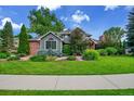 Charming home exterior featuring brick accents, lush landscaping, and a well-manicured lawn at 1321 Ruby Way, Longmont, CO 80504