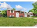Beautiful red brick home featuring a well-kept lawn and attached garage at 6721 Quay Ct, Arvada, CO 80003