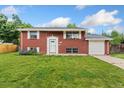 Charming red brick two-story home with a well-manicured lawn, garage, and inviting front entrance at 6721 Quay Ct, Arvada, CO 80003