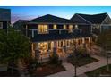 Charming two-story home with a welcoming front porch and landscaped yard at twilight at 9446 E 51St Dr, Denver, CO 80238