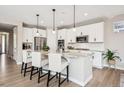 Bright kitchen featuring white cabinets, granite countertops, stainless steel appliances, and an island with seating at 9446 E 51St Dr, Denver, CO 80238