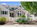 Inviting townhouse exterior with stone accents, a white picket fence, and well-maintained landscaping at 14247 Pikeminnow Pl, Broomfield, CO 80023