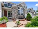 Charming townhouse with stone accents, a cozy patio, and meticulous landscaping at 14247 Pikeminnow Pl, Broomfield, CO 80023