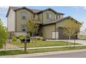 Well-maintained two-story home with green siding, a manicured lawn, and mature landscaping at 4280 Pioneer Pl, Brighton, CO 80601