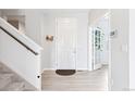 Inviting foyer with hardwood floors, a staircase, and a view into another room at 4280 Pioneer Pl, Brighton, CO 80601