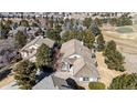 Stunning aerial view of single Gathering home with mature trees, golf course, and community at 47 Herrn Ln, Castle Pines, CO 80108