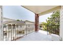Open-air balcony featuring brick pillars and wrought iron railings overlooking well-maintained grounds at 1670 S Deframe St # C2, Lakewood, CO 80228
