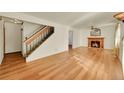 Living room with hardwood floors, a fireplace, and a staircase at 17009 E Loyola Pl, Aurora, CO 80013