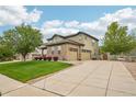 Spacious three-car garage, long concrete driveway, and manicured lawn of this beautiful home at 2605 Gray Wolf Loop, Broomfield, CO 80023
