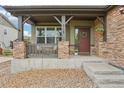 Inviting front porch with stone pillars, seating, and a view of the landscaped front yard at 2605 Gray Wolf Loop, Broomfield, CO 80023