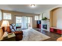 Inviting living room with a fireplace, hardwood floors, a large plush rug and a sliding glass door to the balcony at 22920 E Roxbury Dr # H, Aurora, CO 80016