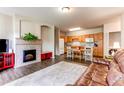 Open-concept living space with a fireplace, wood floors, a cozy rug, and a kitchen area featuring a wooden island at 22920 E Roxbury Dr # H, Aurora, CO 80016