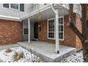 A cozy front porch featuring large windows and a welcoming entrance with a festive wreath at 7501 S Ivanhoe Cir, Centennial, CO 80112
