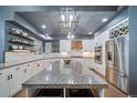 Bright kitchen features white cabinets, granite countertops, stainless steel appliances, and a large center island at 5631 Silver Bluff Ct, Parker, CO 80134
