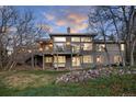 A modern home with a large deck and patio is surrounded by beautiful landscaping and mature trees at 5631 Silver Bluff Ct, Parker, CO 80134