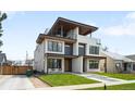 Contemporary home featuring clean lines, a second-story balcony, and lush green lawn at 2926 S Cherokee St, Englewood, CO 80110