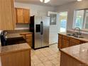 Functional kitchen with stainless steel refrigerator and tile countertops, ready for culinary adventures at 414 S Nelson S St, Lakewood, CO 80226