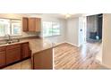 Open kitchen and breakfast nook with granite countertops, wood cabinetry, and hardwood floors at 414 S Nelson S St, Lakewood, CO 80226