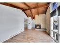 Inviting living room showcases a brick fireplace, wood floors, vaulted ceilings, and natural light from the windows at 414 S Nelson S St, Lakewood, CO 80226