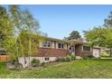 Charming brick home featuring a well-manicured lawn and mature trees surrounding the property at 7901 E Kenyon Dr, Denver, CO 80237