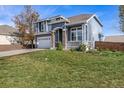 Two-story house with gray siding, white garage door, and landscaped lawn at 12660 Jersey W Cir, Thornton, CO 80602