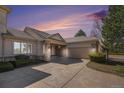 Charming stucco home featuring a tiled roof, stone accents, covered entryway, and attached garage at 13806 E Chenango Dr, Aurora, CO 80015