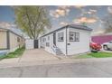Charming home with black and white trim and front porch, showcasing an adjacent storage shed at 14701 E Colfax Ave # A5, Aurora, CO 80011