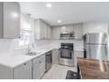 Bright kitchen with stainless steel appliances, modern gray cabinets, and white countertops at 14701 E Colfax Ave # A5, Aurora, CO 80011