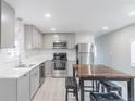 Bright kitchen with stainless steel appliances, a modern countertop, and a wooden dining table at 14701 E Colfax Ave # A5, Aurora, CO 80011