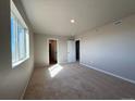 Sunlit bedroom featuring neutral walls, carpet, and a large window offering ample natural light at 48290 Shetland Dr, Bennett, CO 80102