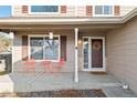 Inviting front porch with coral seating, wreath, and hanging lanterns at 11204 Eaton Way, Westminster, CO 80020