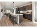 Modern kitchen with stainless steel appliances, white countertops, dark cabinets and seating for four at the island at 4184 Kalamath St, Denver, CO 80211