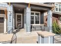 Charming front porch with seating, stone accents, and a well-lit entrance creating a welcoming curb appeal at 9099 Prairie Sky Ln, Lone Tree, CO 80124