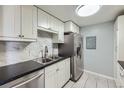 Updated kitchen featuring stainless steel appliances, black countertops, and white cabinets at 4940 E Donald Ave # 8, Denver, CO 80222